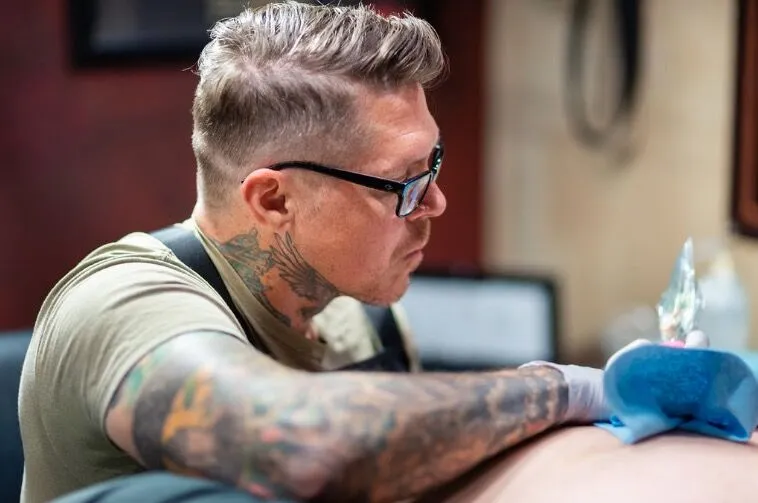 Tattoo artist Jason “Elvis” Martin creating a custom piece inside his private Nashville studio, known for high-integrity, one-on-one sessions.